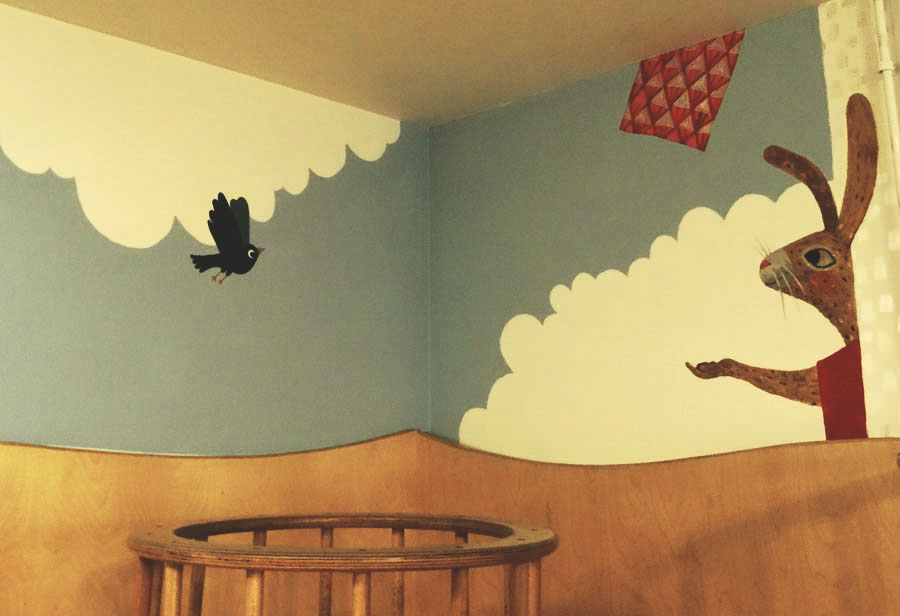 Wandmalerei mit blauer Himmel, weißen Wolken, schwarzem fliegendem Vogel, rotem Drachen und braunem Hasen mit ausgestreckten Armen.