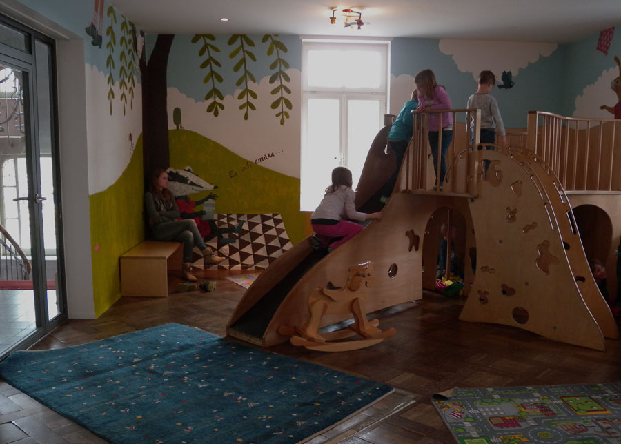 Wandmalerei mit Baum, Blätter, Wolken, Dachsfiguren und Schriftzug 